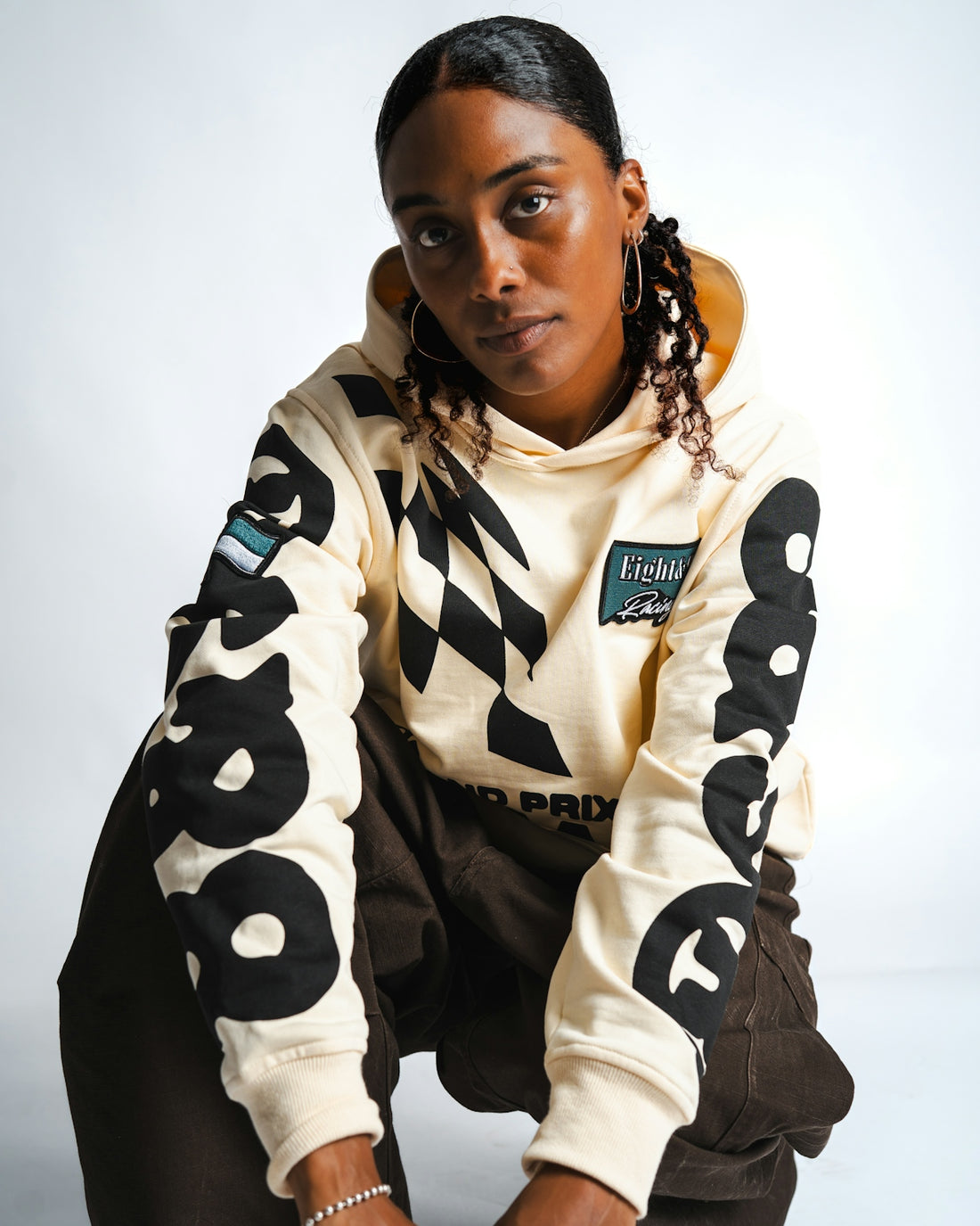 Woman in a cream hoodie with large black numbers.