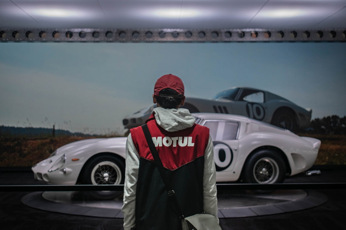 Person in motul vest looks at vintage race cars.